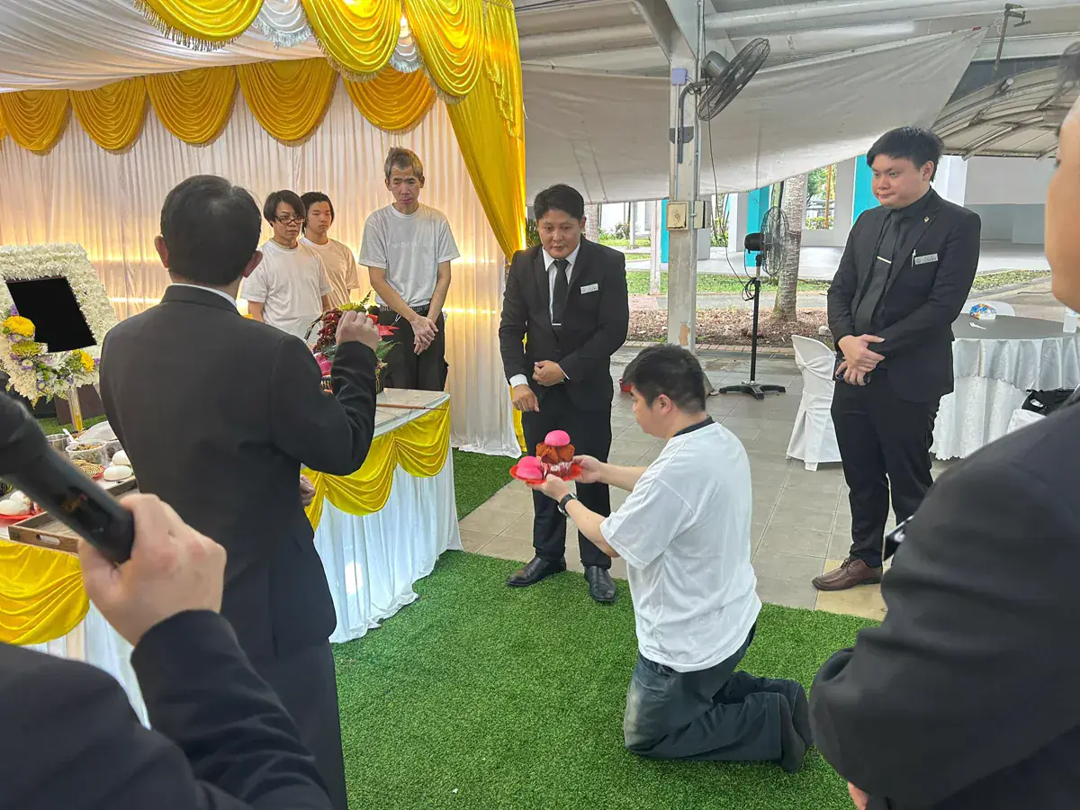 Jeremy speaking with a family during a Buddhist wake in Singapore