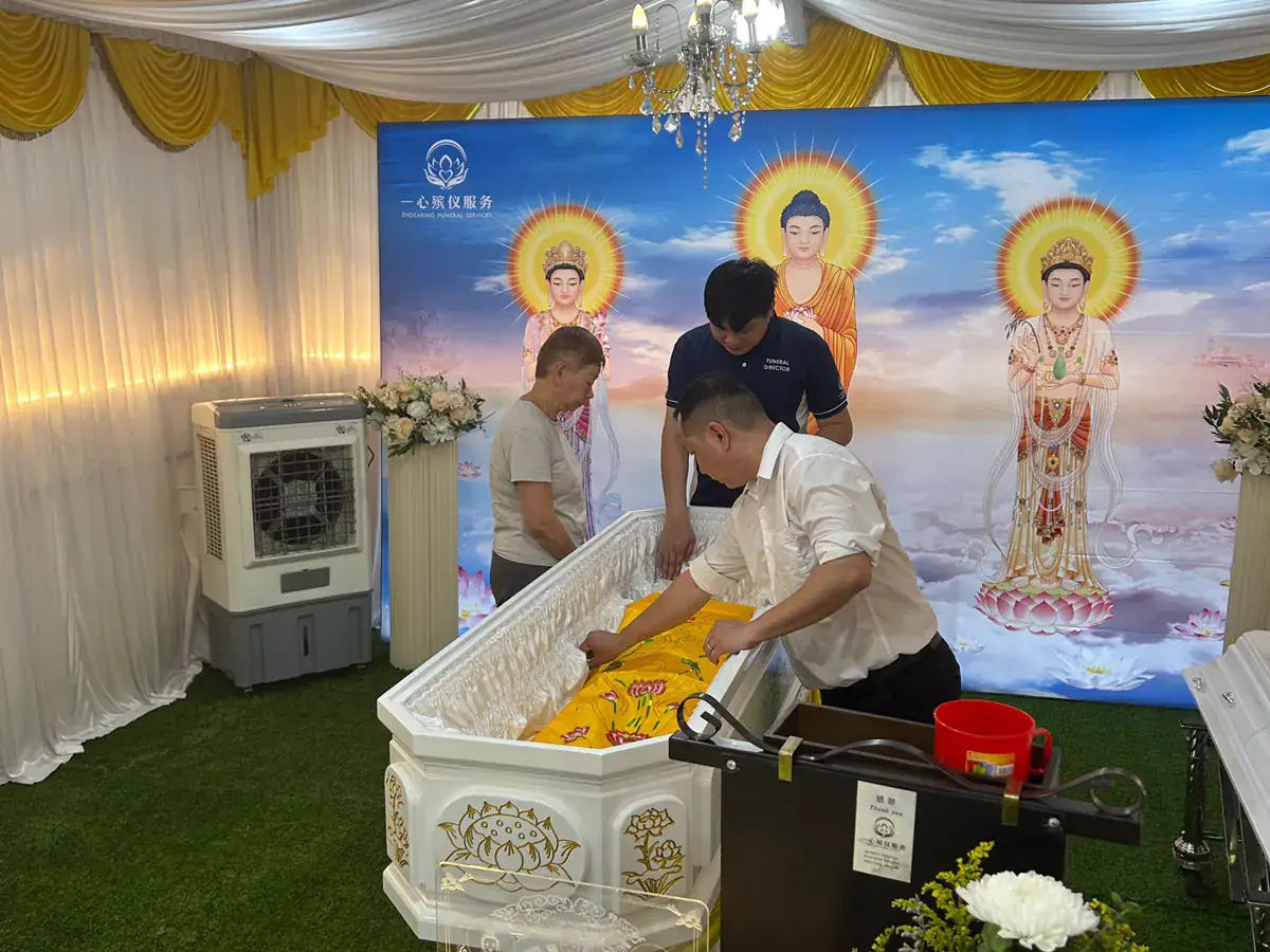 The encoffining ceremony at a Buddhist funeral, with the casket dressed in flowers