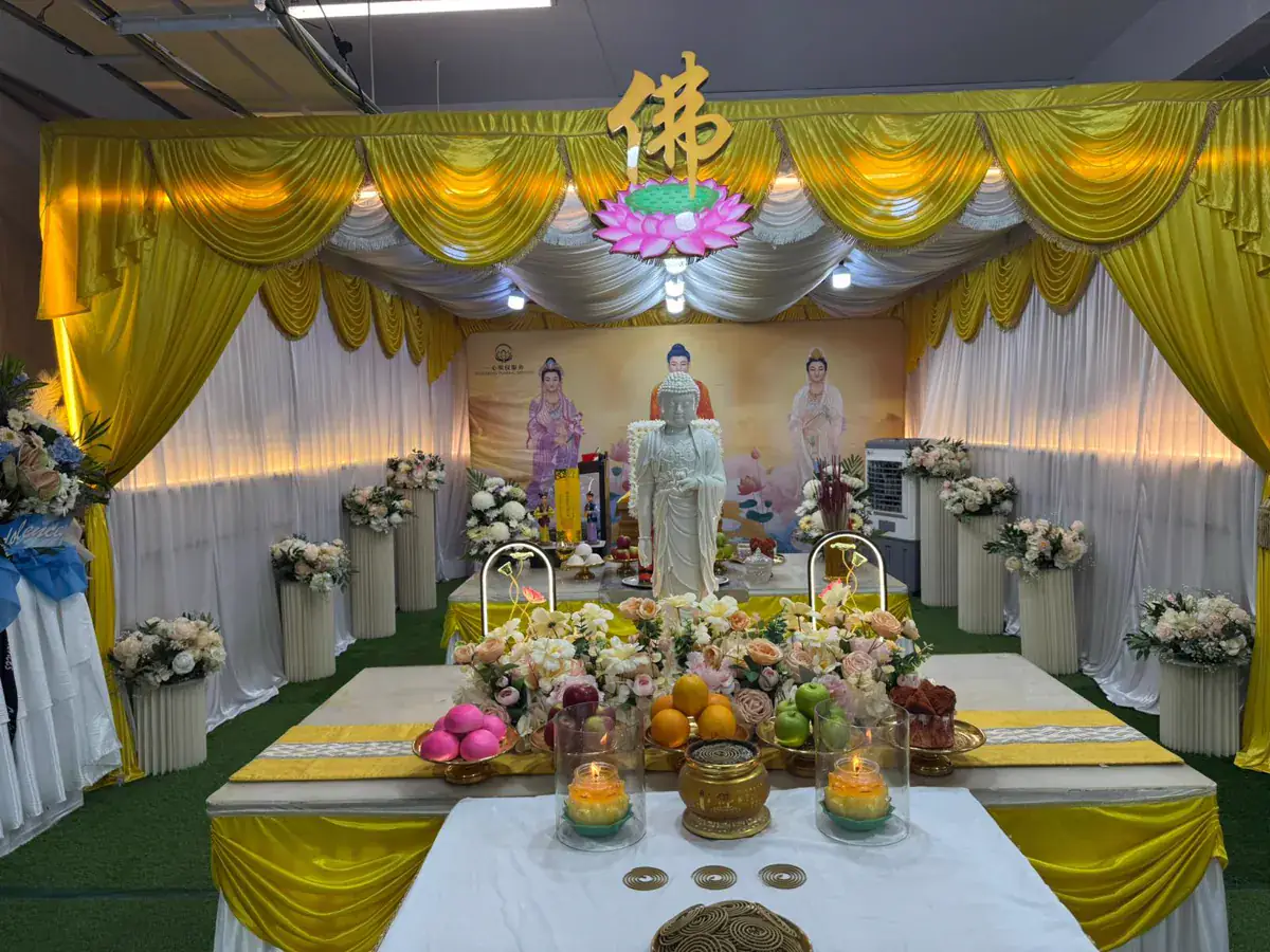Buddhist funeral altar with backdrop, flowers and offerings set up for a wake