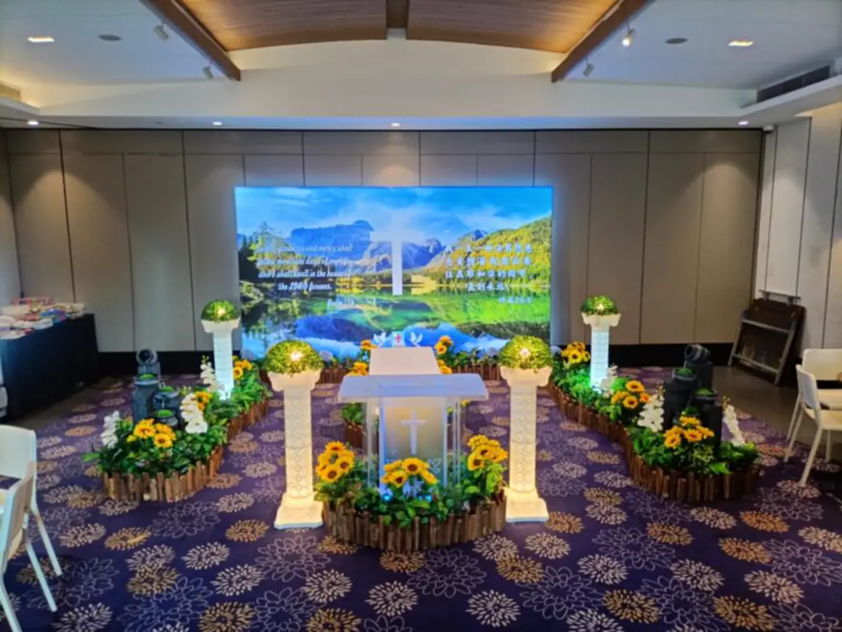A Catholic wake set up with a cross, aisle and floral pillars in Singapore