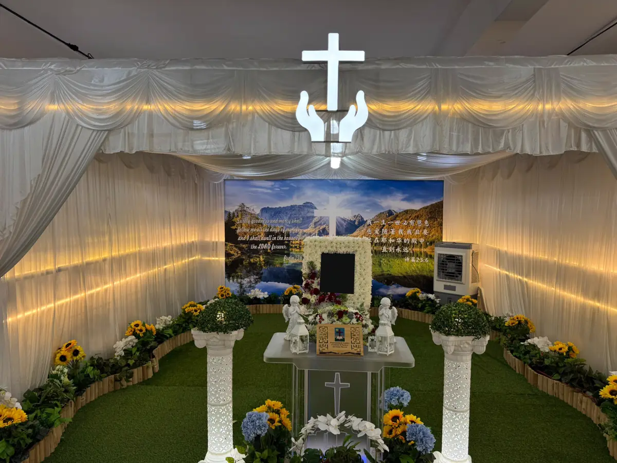 A Catholic wake setup with a cross, altar and floral arrangement in Singapore