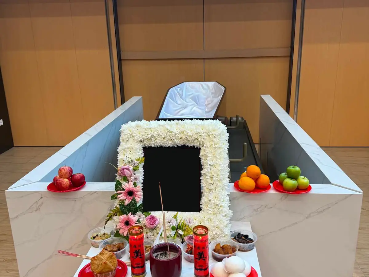 A Wake set up with a cross, aisle and floral pillars in Singapore