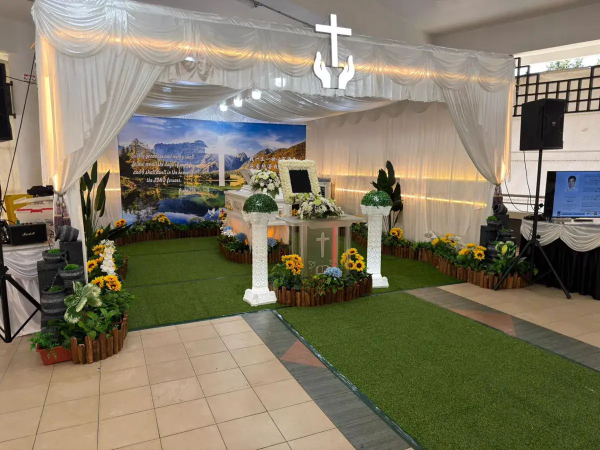 Christian funeral wake with a cross and floral tributes in Singapore