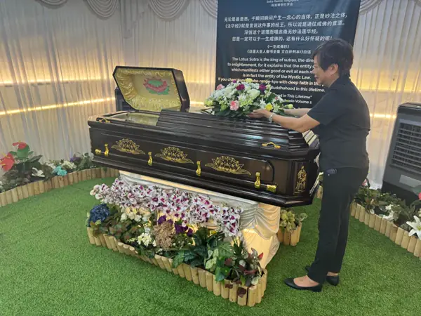 Casket and floral arrangement at a Soka funeral