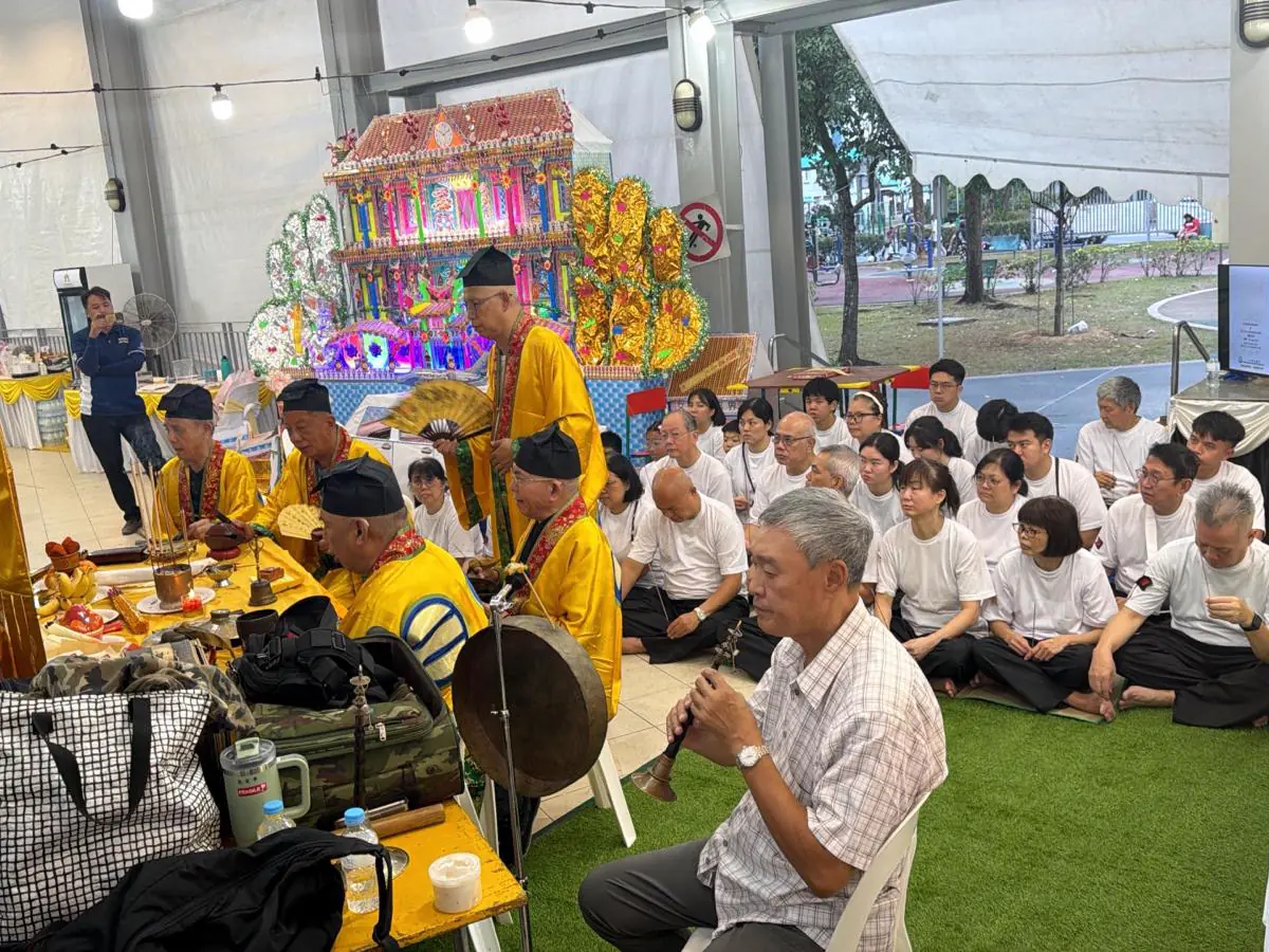 A void deck wake under tentage in Singapore, with guests seated
